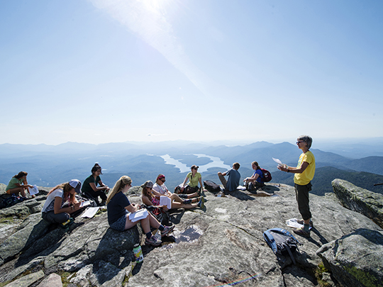 students reading atop a mountain