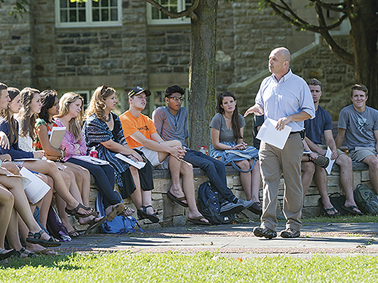 students listening to professor on quad