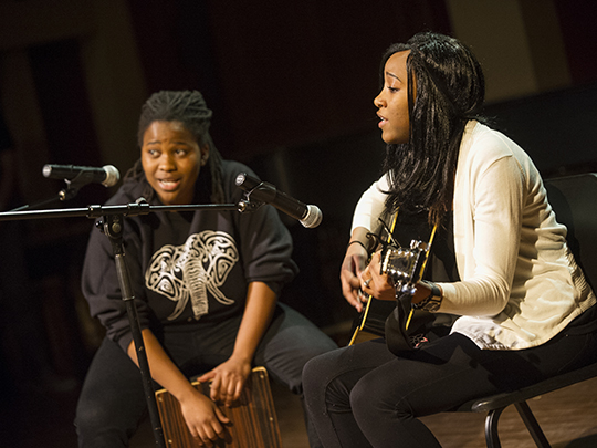 student singing and playing guitar