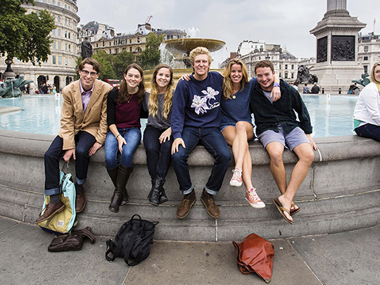 Group of students sitting on fountain